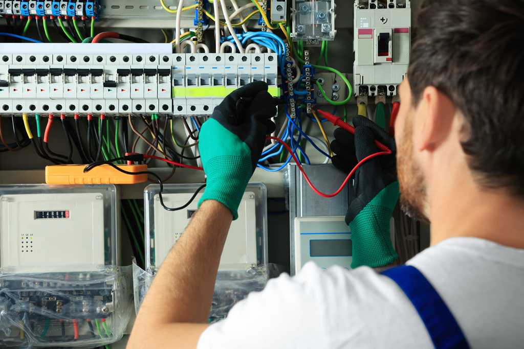 Electrician,Checking,Electric,Current,With,Multimeter,Indoors